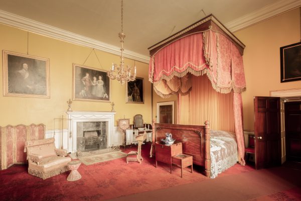 Classic vintage bedroom with a canopy bed and antique furnishings. Chambre vintage classique avec un lit à baldaquin et des meubles anciens.