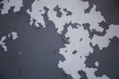 Mur gris à la peinture écaillée par l’humidité